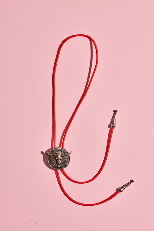 Handmade bolo tie with bright coloured cord and silver turquoise-look hardware, displayed on neutral background – western costume jewellery made in Australia
