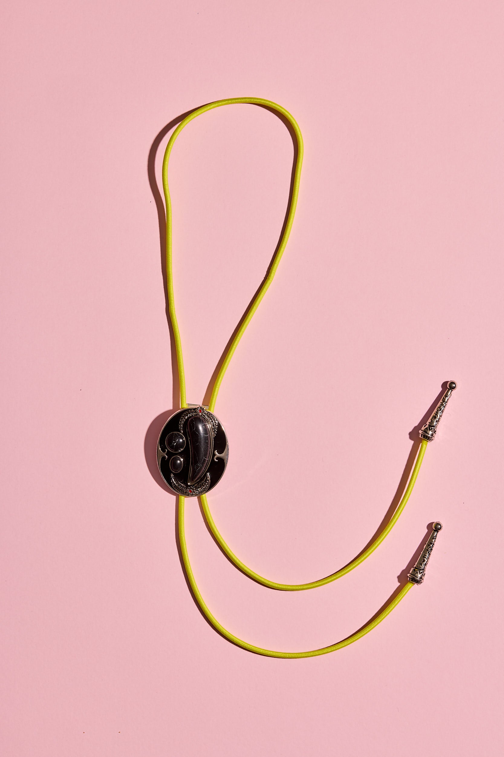 Handmade bolo tie with bright coloured cord and silver turquoise-look hardware, displayed on neutral background – western costume jewellery made in Australia