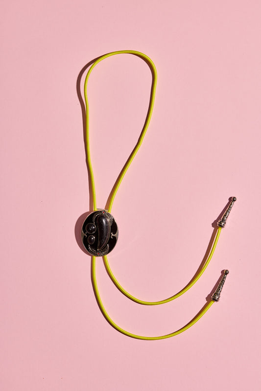 Handmade bolo tie with bright coloured cord and silver turquoise-look hardware, displayed on neutral background – western costume jewellery made in Australia