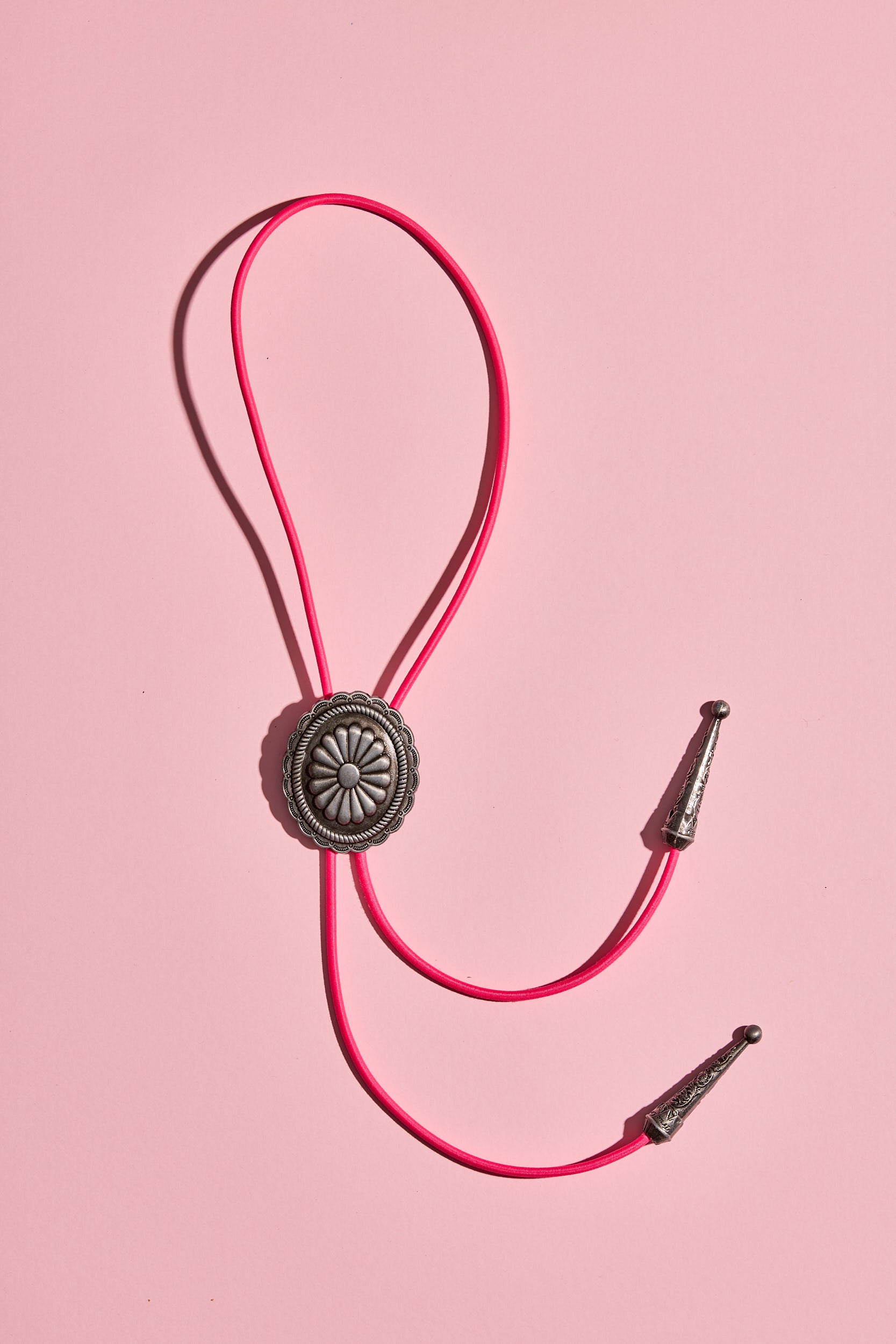 Handmade bolo tie with bright coloured cord and silver turquoise-look hardware, displayed on neutral background – western costume jewellery made in Australia