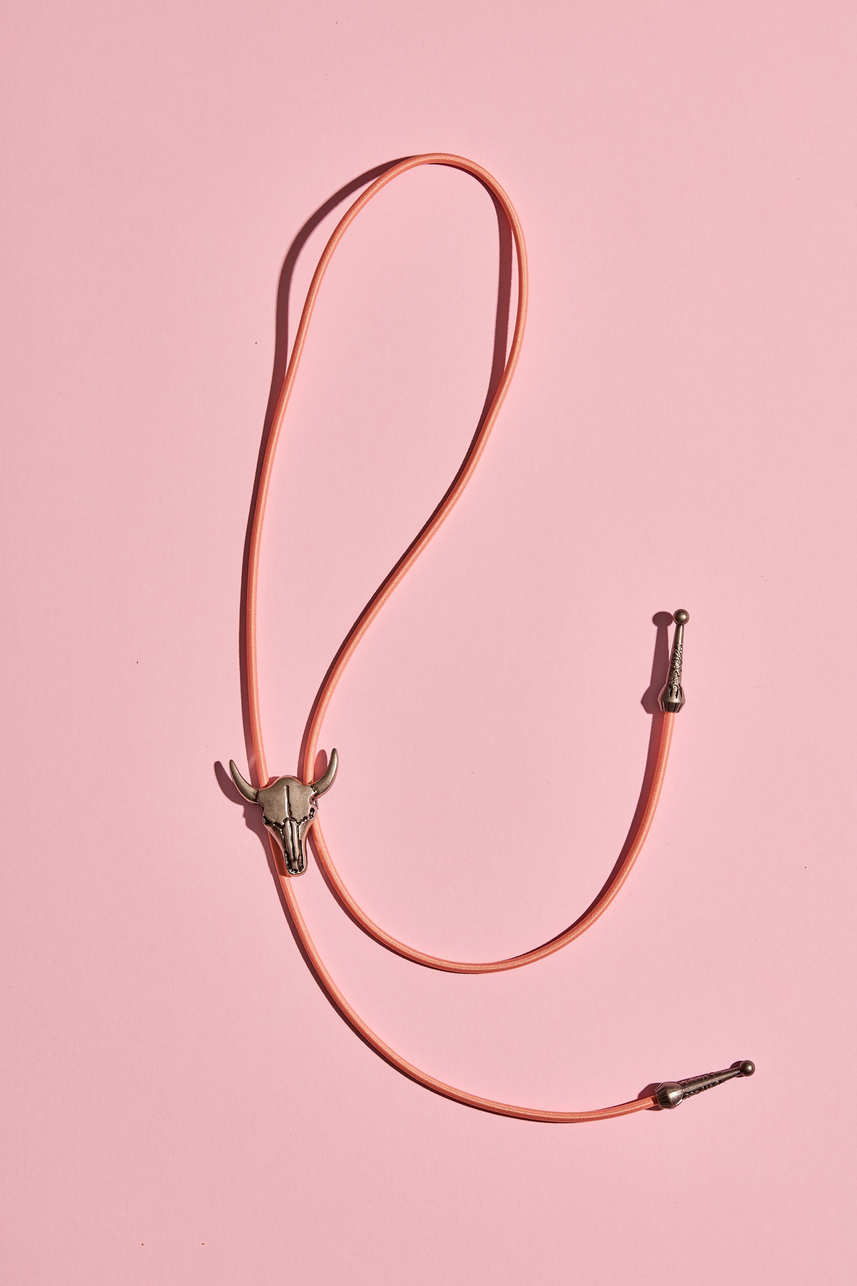 Handmade bolo tie with bright coloured cord and silver turquoise-look hardware, displayed on neutral background – western costume jewellery made in Australia