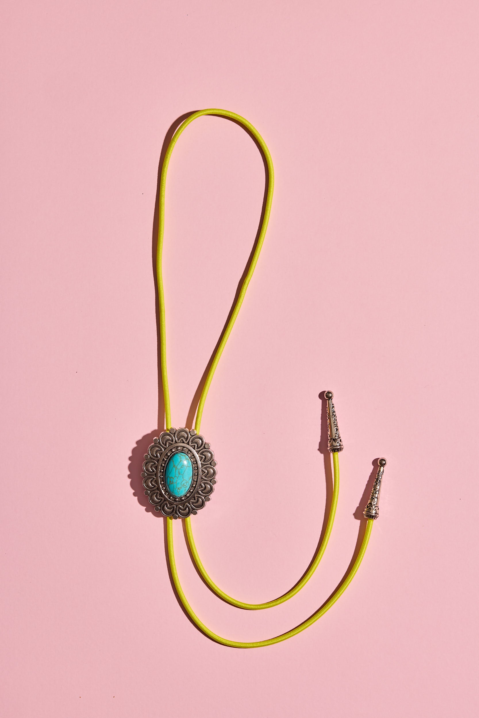 Handmade bolo tie with bright coloured cord and silver turquoise-look hardware, displayed on neutral background – western costume jewellery made in Australia