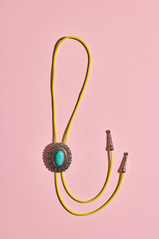 Handmade bolo tie with bright coloured cord and silver turquoise-look hardware, displayed on neutral background – western costume jewellery made in Australia