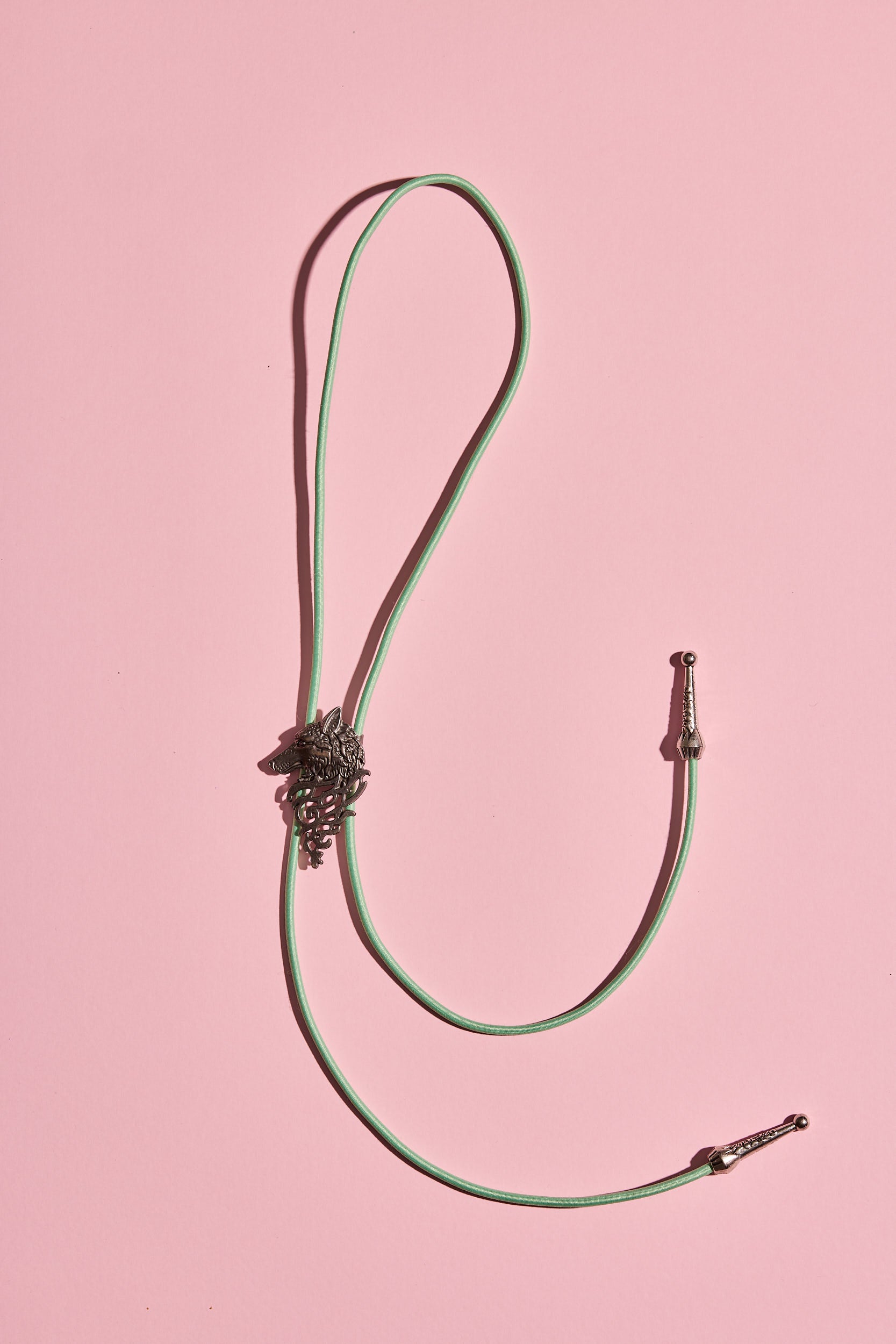 Handmade bolo tie with bright coloured cord and silver turquoise-look hardware, displayed on neutral background – western costume jewellery made in Australia
