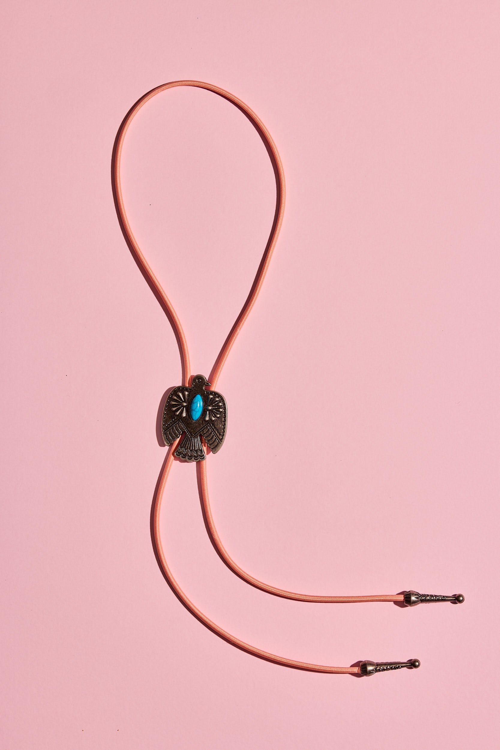 Handmade bolo tie with bright coloured cord and silver turquoise-look hardware, displayed on neutral background – western costume jewellery made in Australia
