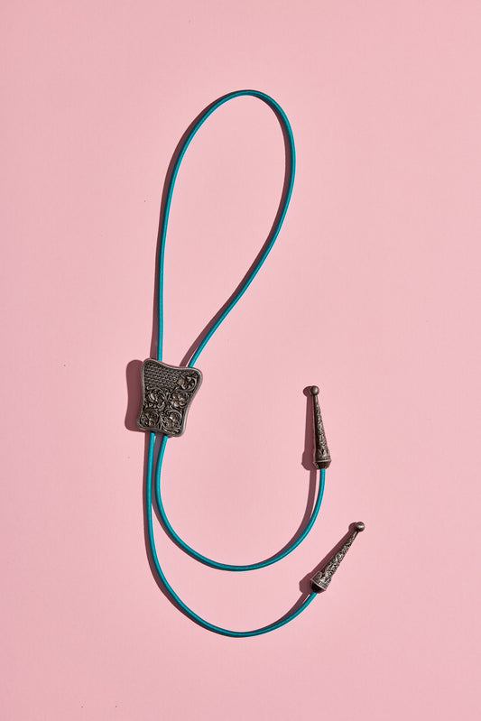 Handmade bolo tie with bright coloured cord and silverlook hardware, displayed on neutral background – western costume jewelry made in Australia